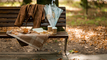 Autumn picnic scene on a park bench