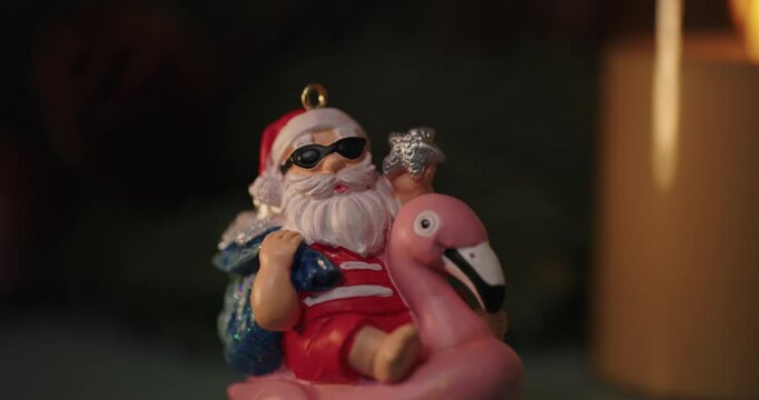 Santa ornament riding a flamingo float with candlelight bokeh
