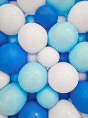 Background of balloons of various sizes in shades of dark blue, light blue, and white, up close. Handmade balloon backdrop arranged tightly in dark blue, light blue, and white for decoration.