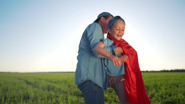 Man and woman hugging in field. A father and son hugging in a field. Love the sunlight and the love of the capes. A couple embracing in a meadow lifestyle.
