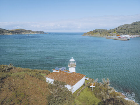 Aerial view of the Faro da Punta Robaleira with a red roof perched on the rugged coastline, overlooking the vast expanse of the sea, Cedeira, A Coru&Atilde;&plusmn;a, Spain.