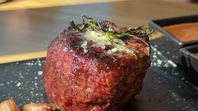 Macro view of coarse salt crystals falling onto a fresh, raw Osso Buco steak. A chef seasons the meat to enhance its flavor before cooking. Gourmet culinary preparation. High quality 4k footage
