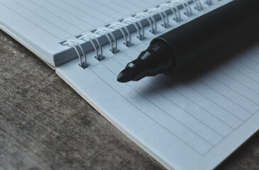 Close up of a black marker on a blank note