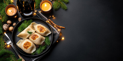 Plate of traditional polish pierogi with golden crust, butter,chopped parsley, arranged on a dark green napkin, surrounded by Christmas tree branches, string lights, and a glowing candle. Copy space
