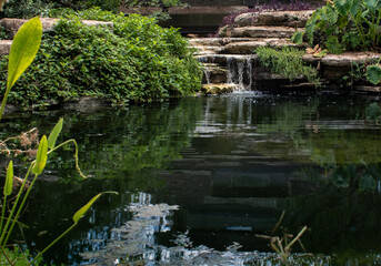 Small pond in a park with waterfall