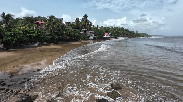 The Turbulent Power of the Sea: Wide Angle View of the Churning Waves and White Surf Washing Over Rugged Shoreline Rocks and Sandy Beach