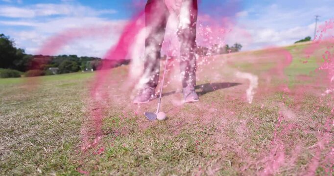 Golfer swinging putter on fairway, generating swirling pink smoke then picking and replacing ball