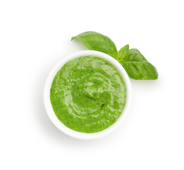 Pesto sauce in bowl and fresh basil leaves isolated on white, top view