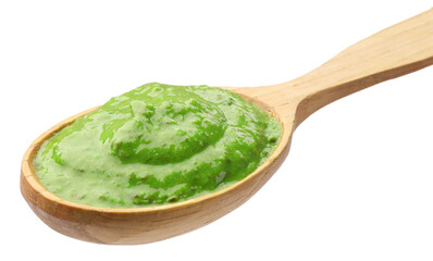 Fresh pesto sauce in wooden spoon isolated on white