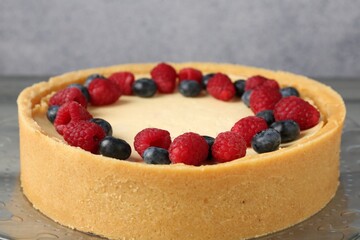 Delicious cheesecake with fresh berries on grey table, closeup