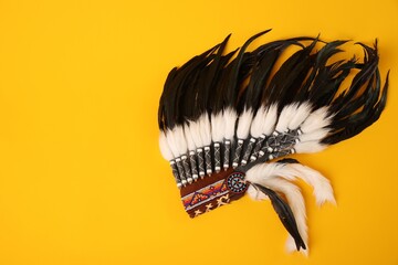 Traditional warbonnet (Native American chief headdress) on yellow background, top view