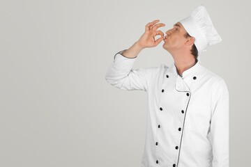 Happy young male chef wear uniform posing
