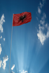 Waving National flag of Albania on flagpole in sky
