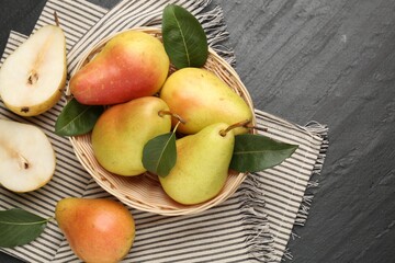 Many fresh pears and leaves on black table, flat lay