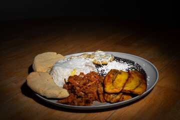 Traditional Venezuelan dish Pabellon Criollo with rice, black beans, shredded beef and fried plantain