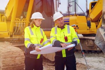 Construction engineers are discussing and using machinery and macros for large-scale construction projects.	
