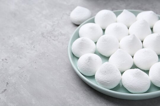 Yummy meringue cookies on grey table, closeup. Space for text