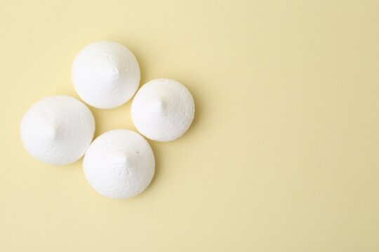 Yummy meringue cookies on beige background, flat lay. Space for text