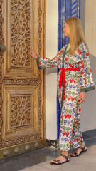 Woman in Uzbek patterned attire admiring traditional architecture in Tashkent