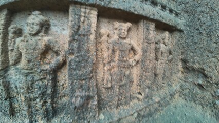 The Rich Texture and Fine Craftsmanship of Ancient Rock-Cut Reliefs Adorning a Wall in the Kanheri Cave Complex, Evoking Spiritual Heritage.