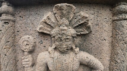 Weathered Ancient Rock-Cut Carving of a Colossal Buddhist Guardian Deity (Dvarapala) with an Intricate Snake Crown at the Entrance of Kanheri Caves, Mumbai
