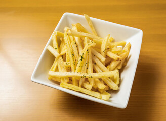 Golden French Fries or Potato Chips Served in Bowl on a Wooden Table top view of japanese food