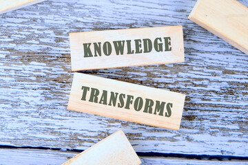 KNOWLEDGE TRANSFORMS concept words is assembled from blocks on wooden boards, top view
