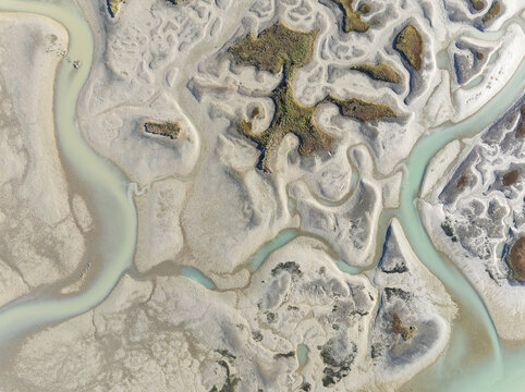 Aerial view of the intricate network of waterways and mudflats, with contrasting textures and earthy tones creating a mesmerizing landscape, Bay of C&Atilde;&iexcl;diz, C&Atilde;&iexcl;diz province, Andalusia, Spain.