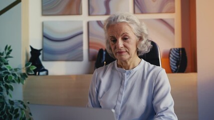 Beautiful businesswoman in her 50s working on laptop and drinking coffee, career