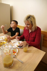 At the festive table, mother and son are treated to food and drinks.
