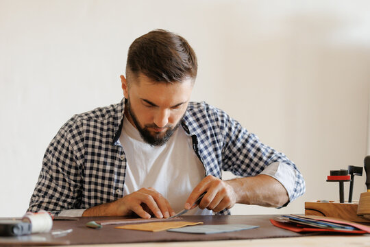 Process craft work, male leather craftsman tailoring in workshop