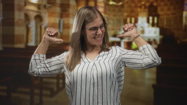Woman with thumbs pointing to herself in a catholic church interior with wooden pews and glowing altar candles visible; confidence joy pride empowerment.