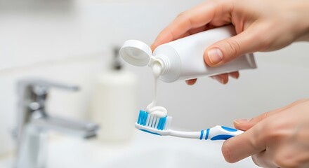 Toothpaste Swirl: Hands Applying Paste to Blue Toothbrush in Bright Bathroom Setting