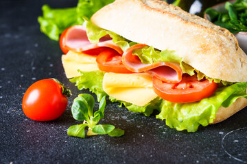 Ciabatta sandwich with lettuce, cheese, tomatoes and ham.