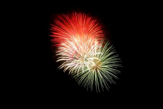 Red and green fireworks explode in the night sky explosion - Powered by Adobe