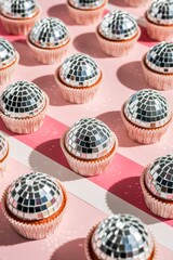 Colorful disco ball cupcakes arranged on a pink surface for a festive celebration or party