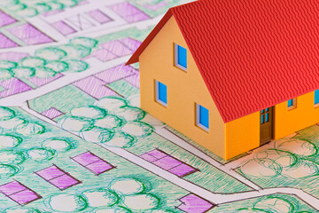 Real Estate concept with home model on imaginary cadastral map o