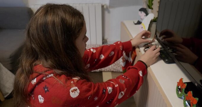 Teenager wearing red Christmas clothes decorates the house for Christmas. Night