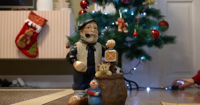 Close-up of the Christmas figure &lsquo;Olentzero&rsquo;. A girl turns on the Christmas tree lights.