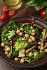 Delicious salad with shimeji mushrooms, chickpeas and broccoli in bowl on table, closeup