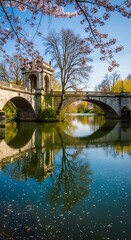 A serene stone bridge reflects beautifully in the tranquil water, adorned with cherry blossoms, casting a peaceful ambiance.