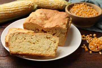Freshly baked cornbread, cobs and seeds on wooden table, closeup