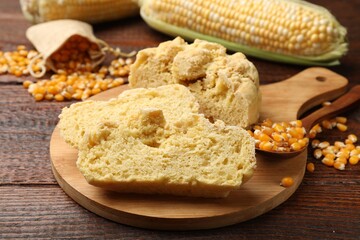 Freshly baked cornbread, cobs and seeds on wooden table, closeup