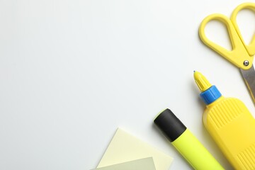 Glue and other stationery on white background, flat lay. Space for text