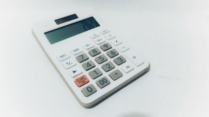 Top view of calculator. White calculator on a bright white paper background. Office supplies. Education. back to school. top view. Calculator on white background with copy space. Finance and economy.