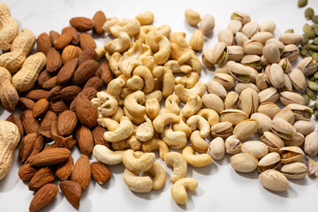 Close up of almond pistachio cashew nuts on light surface various