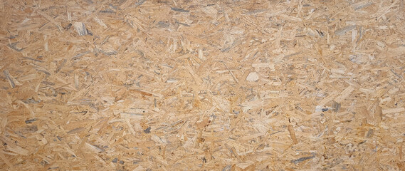 OSB boards made of brown wood chips sanded into wooden background. Wood plank texture background, surface texture of oriented board OSB, Wood board made from piece of wood