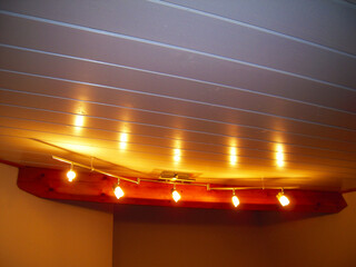 Modern ceiling chandelier with lights on in the living room