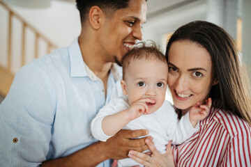 Obraz premium Portrait of young family with small toddler son indoors at home.