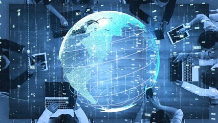 Aerial view of diverse individuals engaged in digital work around laptops, showcasing global connectivity and data representation in an innovative modern workplace. Xenic